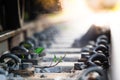 Close up Steel railroad fasteners.Iron nuts fastened to railway tracks.soft focus.Green morning glory in the train tracks