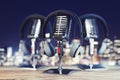 Close up of steel vintage singing vocal microphones on wooden surface and blurry night city background.