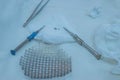 Close-up of a sterile operating table with medical neurosurgical instruments, including a titanium plate, a mesh for the