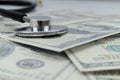 Close-up of a stethoscope on dollar bills, heap of dollars Royalty Free Stock Photo