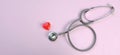 Close up Stethoscope and red heart on pale pink isolated background with copy space for text. Close up, top view. Medical equipme