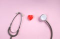 Close up Stethoscope and red heart on pale pink isolated background with copy space for text. Close up, top view. Medical equipme