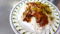 Close up stewed pork leg on white rice with pickled cabbage on white plate or dish at local street food, Thailand. Royalty Free Stock Photo