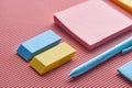 Close up of sticky notes, erasers and pen on pink. Royalty Free Stock Photo