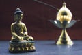 Close up Still Life of antique Meditating Buddha and bell on rustic floor. Faith, Tradition, Spirituality, Prayer, symbols of