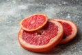 Close up. Bright red mugs of sliced grapefruit on a gray concrete background. Copy space Royalty Free Stock Photo