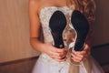 Close Up Still Life of Pair of Plain White Bridal Shoes with High Heels Resting on Rustic Wooden Floor or Table with