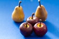 Close up still life of three red apples on blue Royalty Free Stock Photo