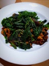 Close up Stir fried century egg with crispy basil leaves on white dish or plate. Royalty Free Stock Photo