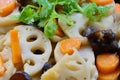 Close-up of stir-fried lotus roots, carrots, wood ear fungus, garnished with Chinese parsley