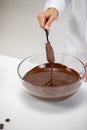Close up stirring and pouring dark melted chocolate  on white background Royalty Free Stock Photo