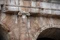 Close-up of a stone capital of the Colosseum with in the background the inner part of the walls soiled by the accumulation of dust