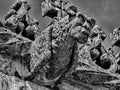 A close up of stone Grotesque carved face gargoyle