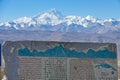 CLOSE UP: Stone sign displays a chart of the snowy Himalaya in the background.