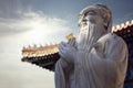 Close-up of stone statue of Confucius, pagoda roof in the background Royalty Free Stock Photo