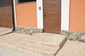 Close up on stone steps with entrance fence door doorbell,security camera, garage door and path. Smart home doorbell.