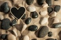 Close-up of stones and heart sticking out of the sand in the sun Royalty Free Stock Photo