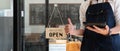 Close up of Store owner turning open sign broad through the door glass and ready to serve. hotel service, cafe Royalty Free Stock Photo