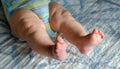 Close-up of straight baby`s legs on blue background. legs of ch Royalty Free Stock Photo