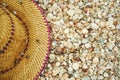 Close-up straw hat on seashells beach. top view