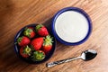 Close up yogurt and strawberries in a blue glass bowl on wooden table Royalty Free Stock Photo