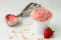 Close-up of strawberry ice cream with caramel chips in white bowl on white table with strawberry, crumbles Royalty Free Stock Photo