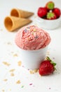 Close-up of strawberry ice cream with caramel chips in white bowl on white table with strawberries Royalty Free Stock Photo