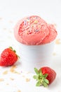 Close up of strawberry ice cream in white bowl on white table with strawberries and crumbles, selective focus, Royalty Free Stock Photo