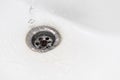 Close up a stream of clean water flows into the sink sewer hole. A jet of water flows into the drain enamel sink Royalty Free Stock Photo