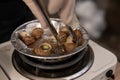 Close up street fast food take away portion of cooked escargot snails with French herbs. cooking on a miniature electric stove Royalty Free Stock Photo