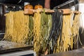 Close up. Street food, night festival. Freshly prepared tagliatelle pasta is dried in a wooden dryer