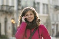 Close-up of a street portrait of a cheerful, successful middle-aged woman with delicate features talking on the phone. Royalty Free Stock Photo