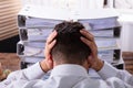 Stressed Businessman In Front Of Stacked Folders Royalty Free Stock Photo