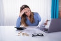 Stressed Businesswoman With Invoice At Workplace