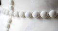 Close-up of a string of white fabric-covered buttons on a textured white surface Royalty Free Stock Photo