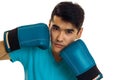 Close up of strong young brunette man in blue gloves practicing boxing and looking at the camera isolated on white Royalty Free Stock Photo