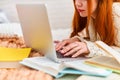 Cute teen girl doing homework while lying on the bed at home. distance learning Royalty Free Stock Photo