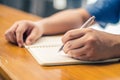 Close up of student hand writing on book with pen Royalty Free Stock Photo