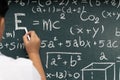 Close up student hand writing math equations on chalkboard education school learning knowledge concept Royalty Free Stock Photo