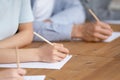 Close up of students writing passing test in classroom