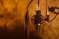 Close up studio condenser microphone on stand and anti-vibration mount. Live recording with colored lights background. Side view. Royalty Free Stock Photo