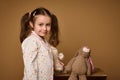 Close-up cute baby girl with two ponytails holding her plush toys and cutely smiles confidently looking at camera, isolated over Royalty Free Stock Photo