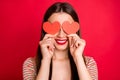 Close-up studio photo portrait of pretty charming lady with toothy beaming smile holding two small paper cards in hands