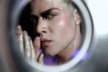 Close up studio portrait of beautiful young man with face art, violet light Royalty Free Stock Photo