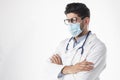 Studio portrait of male doctor wearing surgical mask while standing at isolated white background Royalty Free Stock Photo