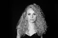 Portrait of a pretty curly blonde woman, wearing black dress Royalty Free Stock Photo