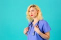 Smiling young female doctor or nurse wearing blue scrubs and stethoscope Royalty Free Stock Photo