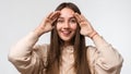 Close up studio portrait of a Young beautiful brunette woman looking through her fingers like binoculars Royalty Free Stock Photo