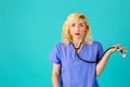 Young female doctor or nurse wearing blue scrubs with hand out Royalty Free Stock Photo