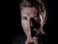 Portrait of young 30s man with finger on his lips in silence and shut up hand gesture warning or threatening not to speak in polit Royalty Free Stock Photo